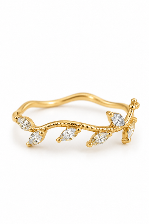 Bague dorée motif branche végétale avec pierres claires en forme de feuilles, fond blanc